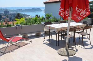 a patio with a table and chairs and a cocacola umbrella at Apartments Portorose in Portorož +13 photos