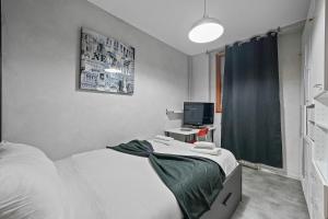 a bedroom with a bed and a desk with a television at Welcome to Village Parisien 2 in Saint-Maur-des-Fossés