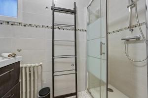 a shower with a glass door in a bathroom at Welcome to Village Parisien 2 in Saint-Maur-des-Fossés