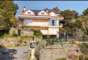 a house on a hill with a stone wall at Casetta Panorama - Vista mare panoramica 2 camere relax in Camporosso
