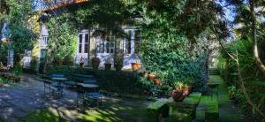 un bâtiment recouvert de lierre avec des tables et des chaises dans une cour dans l'établissement Casa de Esteiro, à Caminha