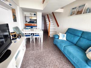 a living room with a blue couch and a table at Apartamentos con vistas al mar in Platja  d'Aro