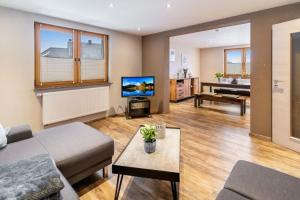 a living room with a couch and a television at Ferienwohnung Eifelhöhe Pützer in Hellenthal