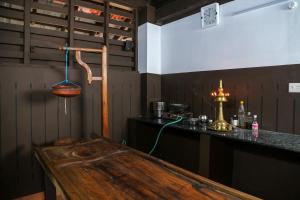 a kitchen with a wooden table and a counter at Akkara Homestay in Kottayam
