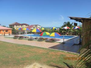 a swimming pool with colorful umbrellas and a pool at Jamaica Inn Guest House in Bortianor +46 photos