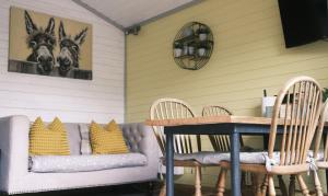 a porch with chairs and a table and a couch at Willow Lodge in West Wellow