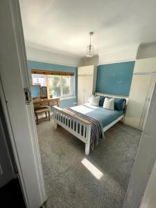 a bedroom with a bed with a blue headboard at Surrey Street Retreat in Wallasey