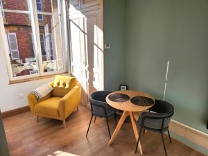 a living room with a table and chairs and a couch at Suite Delvincourt - Rue Calme centre ville - Parking gratuit - Proche Gare in Charleville-Mézières