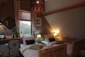 two twin beds in a room with a window at B&B De Zwerver in Oldehove