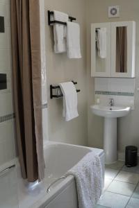 a bathroom with a bath tub and a sink at Hook Farm Cottages in Royal Wootton Bassett +28 photos