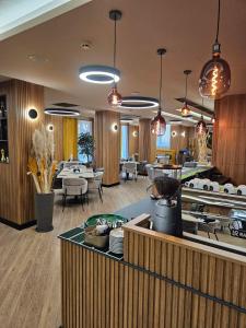 a restaurant with tables and chairs and pendant lights at Park Hotel Plovdiv in Plovdiv