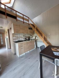 a kitchen with a spiral staircase in a house at Domki Eridan nad morzem in Wisełka
