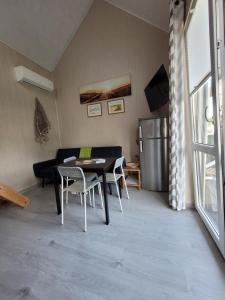 a living room with a table and chairs and a couch at Domki Eridan nad morzem in Wisełka +3 photos