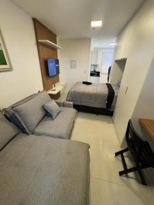 a living room with a couch and a bed at Flat Super Luxo - Central - Otima localizacao - Novo in Volta Redonda