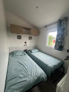 due letti in una piccola stanza con una finestra di 538 mobile home grand confort a La Teste-de-Buch