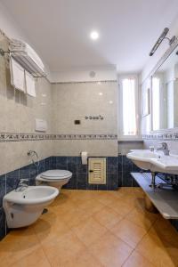 łazienka z dwiema umywalkami i dwiema toaletami w obiekcie Crosti Apartments w Rzymie