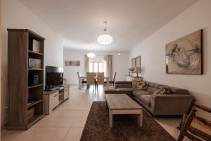 a living room with a couch and a tv and a table at Larger than usual 3BD Apartment in Sliema