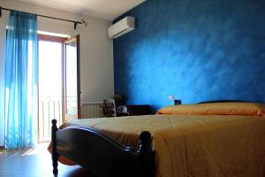Dormitorio azul con cama y pared azul en Agriturismo La Casa di Bacco en Agrigento