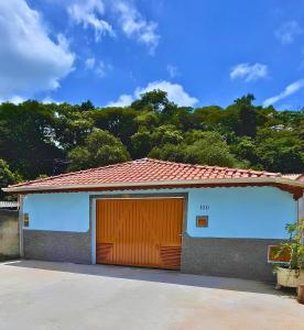 a building with a garage with a large door at Casa Temporada - Centro Guararema SP in Guararema