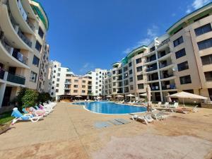 a pool with chairs and umbrellas next to some buildings at Avalon Lux in Sunny Beach +8 photos