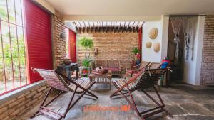 a group of chairs sitting on a porch at Casa charmosa a beira-mar em Paripueira - AL in Paripueira