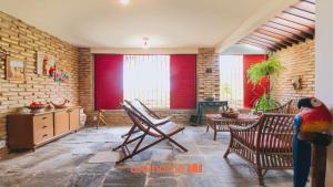a living room with red blinds and a parrot statue at Casa charmosa a beira-mar em Paripueira - AL in Paripueira