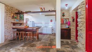 a kitchen with a wooden table and a brick wall at Casa charmosa a beira-mar em Paripueira - AL in Paripueira +24 photos