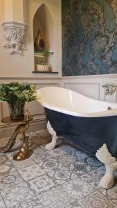 a bathroom with a blue and white bath tub at Parc-Le-Breos House in Penclawdd +32 photos
