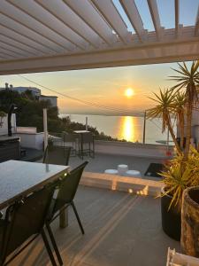a patio with a view of the ocean at sunset at Appartement Duplex Rosas avec terrasse magnifique jacuzzi vue mer in Roses