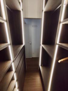 un vestidor con estanterías de madera y luces en BIG Luxury - California M4, en Milán