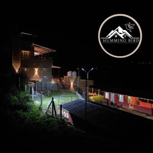 a building with a sign that reads hunting elite at night at Humming Bird in Kotagiri