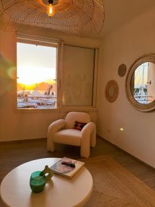 a living room with a table and a chair and a window at Port Saint-Tropez in Saint-Tropez