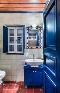a blue bathroom with a sink and a toilet at Papigo Villas in Papigko +34 photos