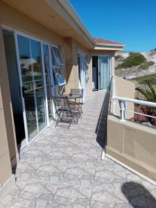 a patio with chairs and tables on a house at Harbour Close Home in Cape Town