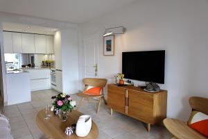 a living room with a television and a kitchen at Les Sanguinaires N'7 - T2 Vue Mer, Piscine & Plage in Ajaccio +29 photos