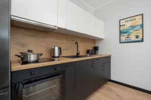 a kitchen with a sink and a stove at Stylowe Apartamenty w Centrum Gdyni i Blisko Plaży by Noclegi Renters in Gdynia
