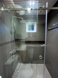 um banheiro com chuveiro e porta de vidro em RUBY Suites em Baguio mais 16 fotografias