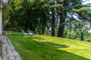a park with two chairs and a table in the grass at Studio Dépendance du Château - Kitchenette in Gennes +5 photos