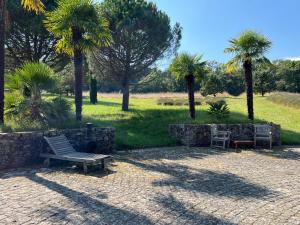 a park with a bench and some palm trees at Studio Dépendance du Château - Kitchenette in Gennes