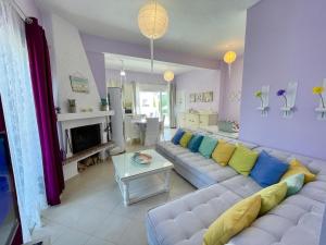a living room with a white couch with colorful pillows at AIR, Oneiropagida, Aegina in Vathí