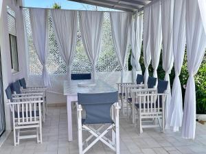 a table and chairs on a patio with white curtains at AIR, Oneiropagida, Aegina in Vathí