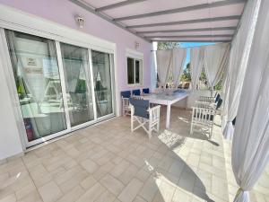 a dining room with a table and chairs on a patio at AIR, Oneiropagida, Aegina in Vathí