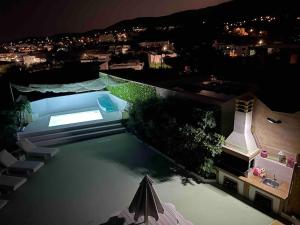 a view of a swimming pool at night at AIR, Oneiropagida, Aegina in Vathí