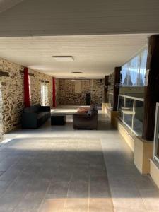 a large living room with couches and a stone wall at L'Essart in Saint-Philbert-de-Bouaine