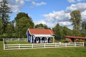 a blue and white barn with a white fence at Błękit Żuław in Przemysław