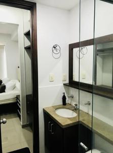 un baño con lavabo y espejo en Aparta estudio Bucaramanga, en Bucaramanga