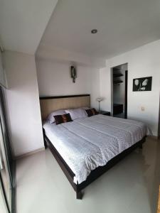 Un dormitorio con una cama grande en una habitación blanca. en Aparta estudio Bucaramanga, en Bucaramanga