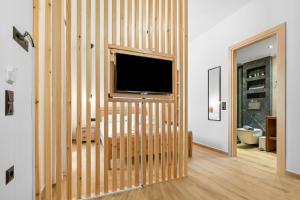 ein Wohnzimmer mit einer Holzwand und einem Flachbild-TV in der Unterkunft Carina Studios Lefkada 2 in Lefkada Town