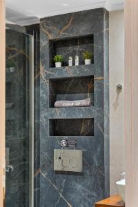 ein Bad mit einer Dusche mit schwarzem Marmor in der Unterkunft Carina Studios Lefkada 2 in Lefkada Town