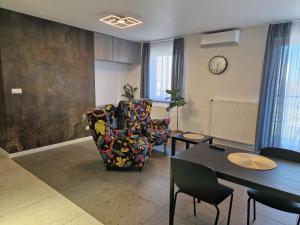 ein Wohnzimmer mit zwei Stühlen und einem Tisch in der Unterkunft Apartament Katowice Tysiąclecie in Kattowitz